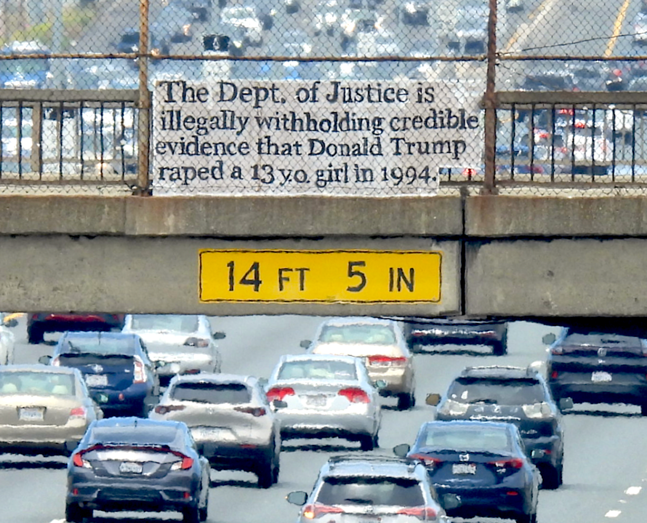 Photo of banner over freeway traffic that reads "The Department of Justice is illegally withholding credible evidence that Donald Trump raped a 13 year old girl in 1994." Purpose is to 1) transmit the stated message and 2) demonstrate the superiority of cardboard to cloth for lettering and posting political messages and 3) demonstrate that citizens can do this.