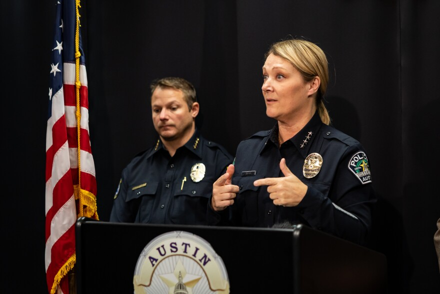 Lisa Davis, dressed in a police uniform, speaks at a podium while Mayor Kirk Watson stands behind her.